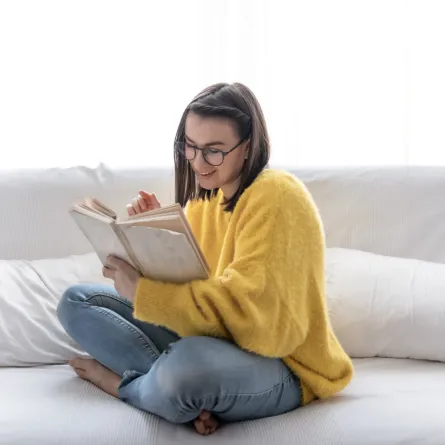 فتاة تعبر عن متعتها بقراءة كتاب  - المصدر freepik