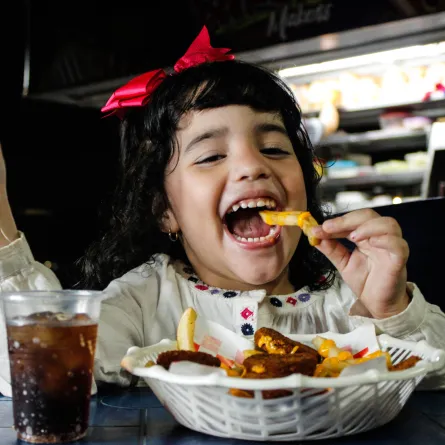 صورة لطفلة تتناول وجبة سريعة