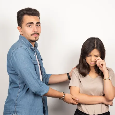 زوج يربت على كتف زوجته بعد أن اكتشف أنه يزعجها   