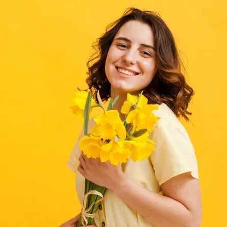 سيدة تحمل زهرة الربيع المسائية Image By Freepik