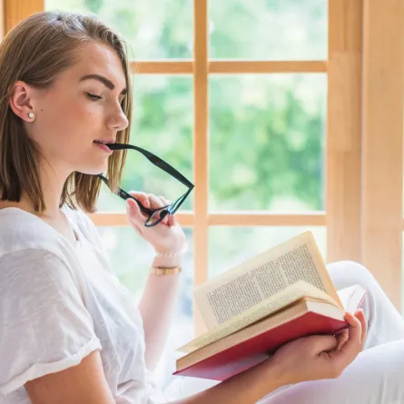 شابة تقرأ رواية باستمتاع وانسجام