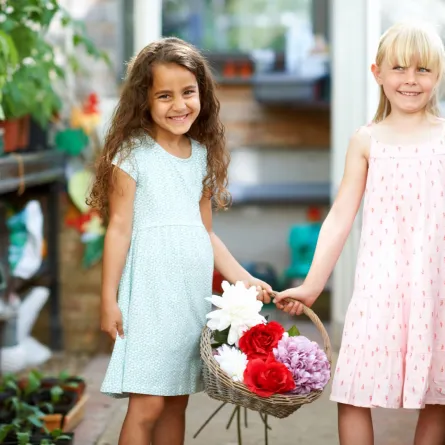 صورة طفلتين تحملان الزهور