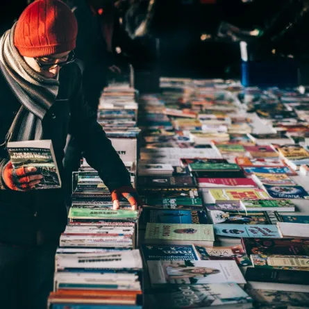 رجل يتصفح بعض الكتب بأحد المعارض بالشارع