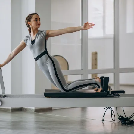 سيدة تمارس البيلاتس الأرضي للحصول على اللياقة البدنية Image By Freepik