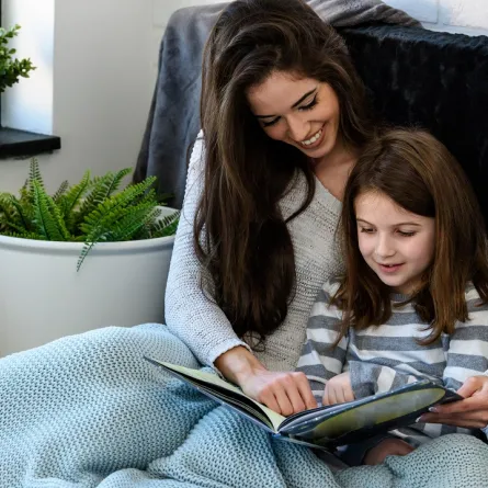 صورة لأم تحكي قصة لابنتها