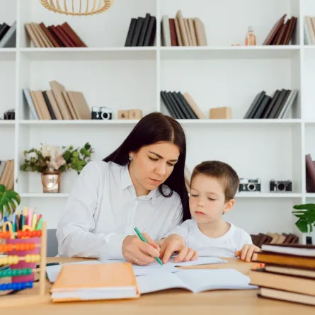 صورة أم تشرف على دراسة الطفل