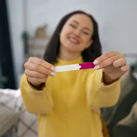 صورة لامرأة تحمل اختبار حمل منزلي