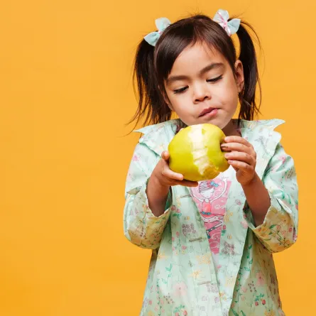 صورة لطفلة تتناول التفاح