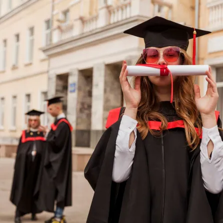 فتاة سعيدة بتخرجها تقبل شهادتها بمرح   