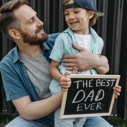 طفل يحمل لوحة مكتوب عليها أفضل أب