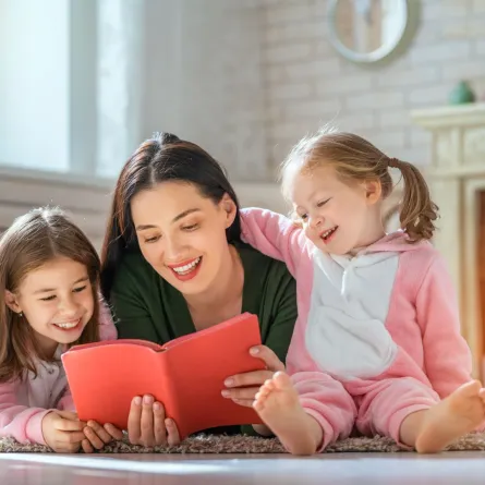 صورة أم تقرأ القصص لطفلتيها