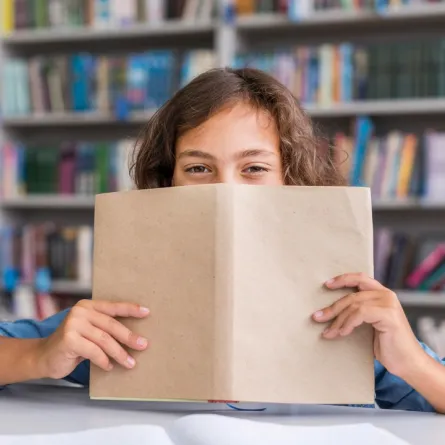 صورة لطفلة تجلس بالمكتبة