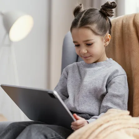 صورة لطفلة تستخدم جهازها الالكتروني الخاص 