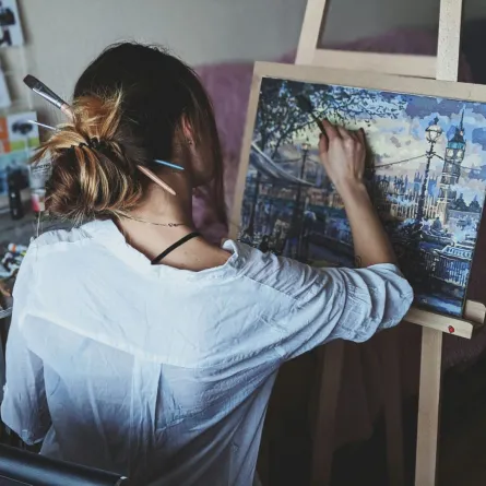 فتاة ترسم لوحة حيث يمكن تعلم مهارات إبداعية جديدة في إجازة الصيف كالرسم