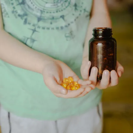 صورة طفل بيده حفنة من زيت السمك