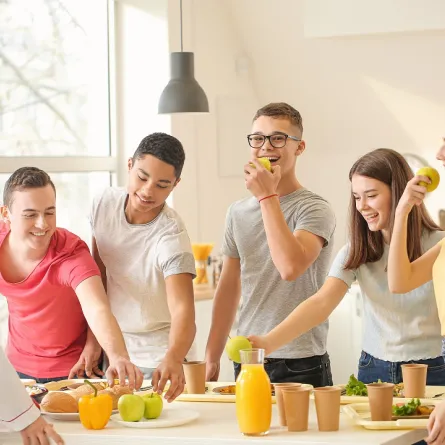 صورة لعدد من المراهقين يتناولون طعاماً صحياً