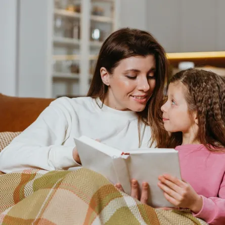 صورة لأم تقرأ لطفلتها