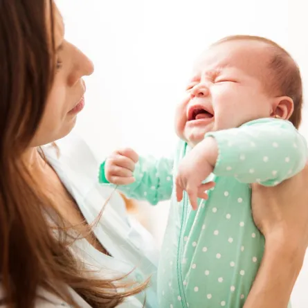 صورة لأم تحمل رضيعها الباكي