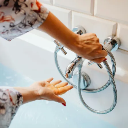 امرأة تتحسس حرارة الماء