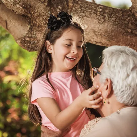 صورة لطفلة تداعب جدتها