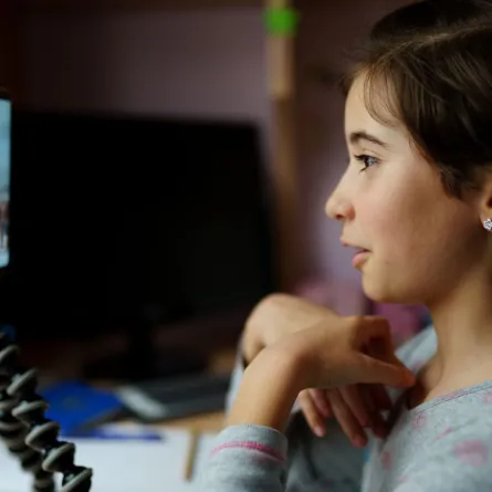 صورة طفلة أمام قناة على السوشيال ميديا