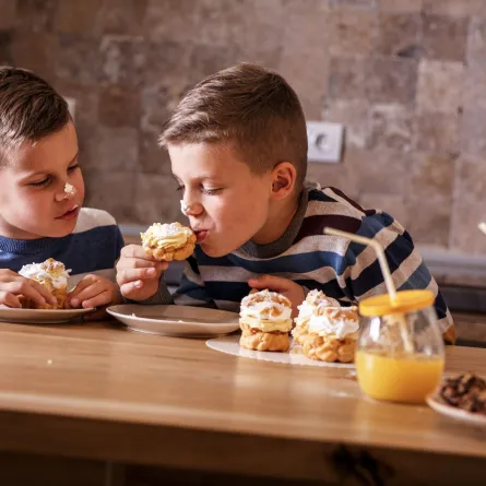 صورة طفلين يأكلان الحلوى بشغف