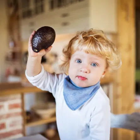 صورة طفل يرفع حبة الأفوكادو