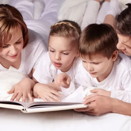 صورة ابوين يقرآن القصص لأطفالهما