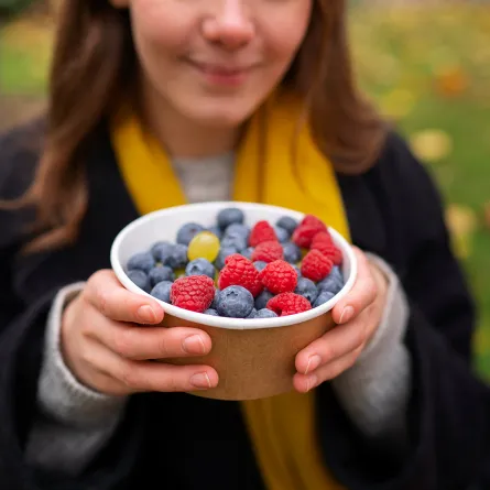 فتاة تحمل طبقاً مليئاً بالفواكه الفواكة  Image By Freepik