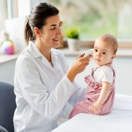 صورة لطبيبة تفحص اذن الطفل