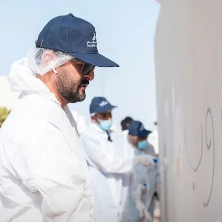 صبغ الجدران المتأثرة بالكتابات العشوائية - الصورة من وكالة الأنباء الإماراتية "وام"