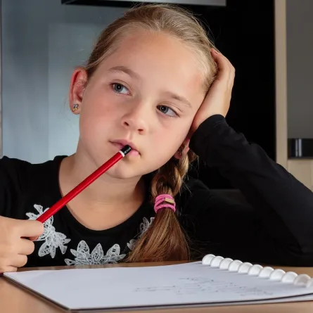 صورة لطفلة تُعِدُّ واجب المدرسة