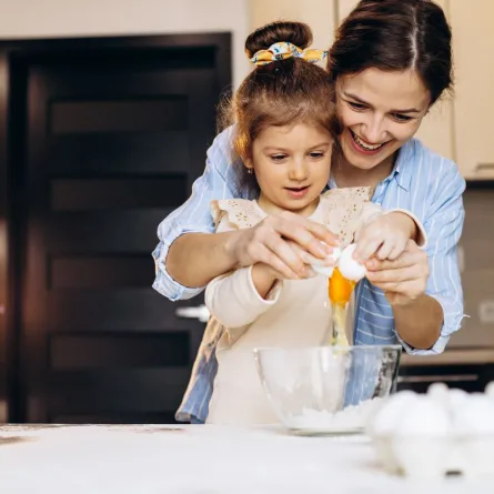 صورة لام تشجع طفلتها على تناول اصنافا معدة من البيض