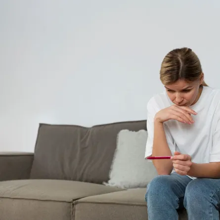 صورة لحامل في حيرة مع جهاز فحص حمل منزلي