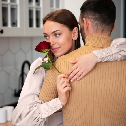 زوجة تشم وردة حمراء جميلة أهداها لها زوجها حيث تُعد من مفاتيح نجاح العلاقة الزوجية - المصدر: freepik