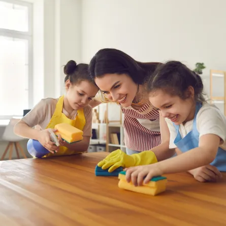 أم وابنتاها الصغيرتان تقومان بأعمال المنزل