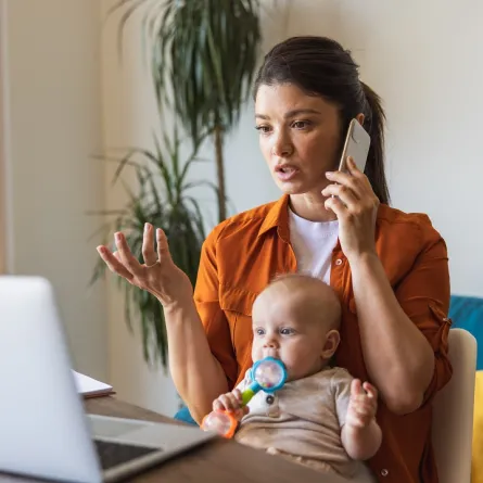 صورة لأم ترعى طفلها وهي تعمل