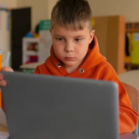 طفل يجلس أمام الكمبيوتر 