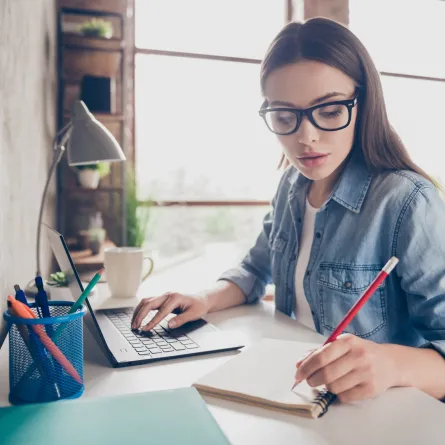 شابة يبدو عليها ملامح الجدية وهي تجتهد في عملها على جهازها المحمول