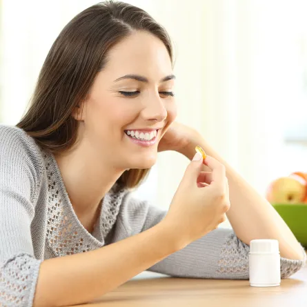 سيدة تتناول المكملات الغذائية لتوفير العناصر الغذائية