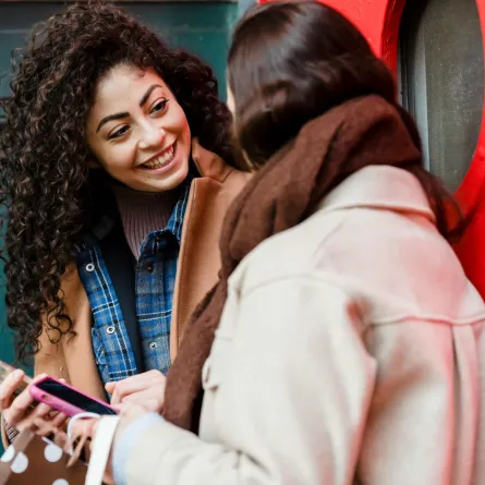 صديقتان تقرآن رسالة صباحية مبهجة عبر الموبايل