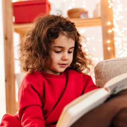 صورة لطفلة تمسك بالكتاب