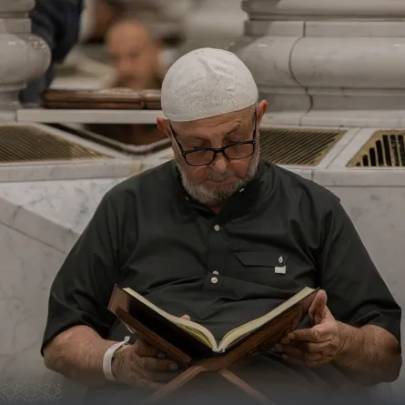 معتمر يجلس داخل المسجد النبوي يقرأ القرآن - الصورة من حساب الهيئة العامة للعناية بشؤون الحرمين المسجد النبوي على منصة إكس