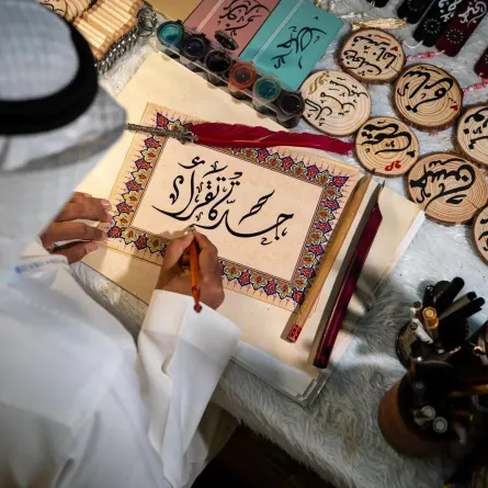 خطاط سعودي يرسم شعار معرض جدة للكتاب "جدة تقرأ" - الصورة من وكالة الأنباء السعودية "واس"