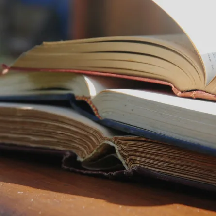 مجموعة من الكتب المفتوحة موضوعة على الطاولة 