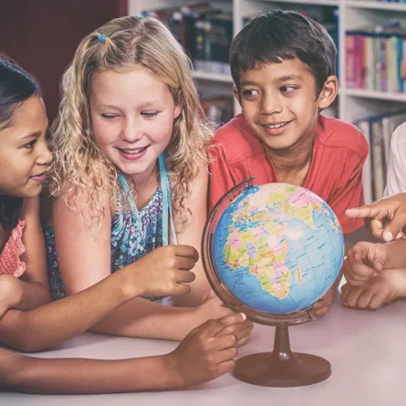 صورة أطفال يجتمعون حول الكرة الأرضية