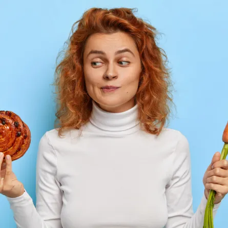 سيدة حائرة بين تناول الخضار أو الحلوى- المصدر freepik