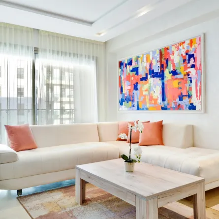 صالة منزلية مع لوحة تجريدية تزين الحائط