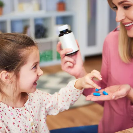 صورة لأم تعطي طفلها الكالسيوم بوصفه مكملاً غذائياً