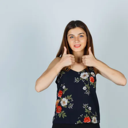 فتاة ترفع إبهامي يديها بسعادة، معبّرةً عن الفرح